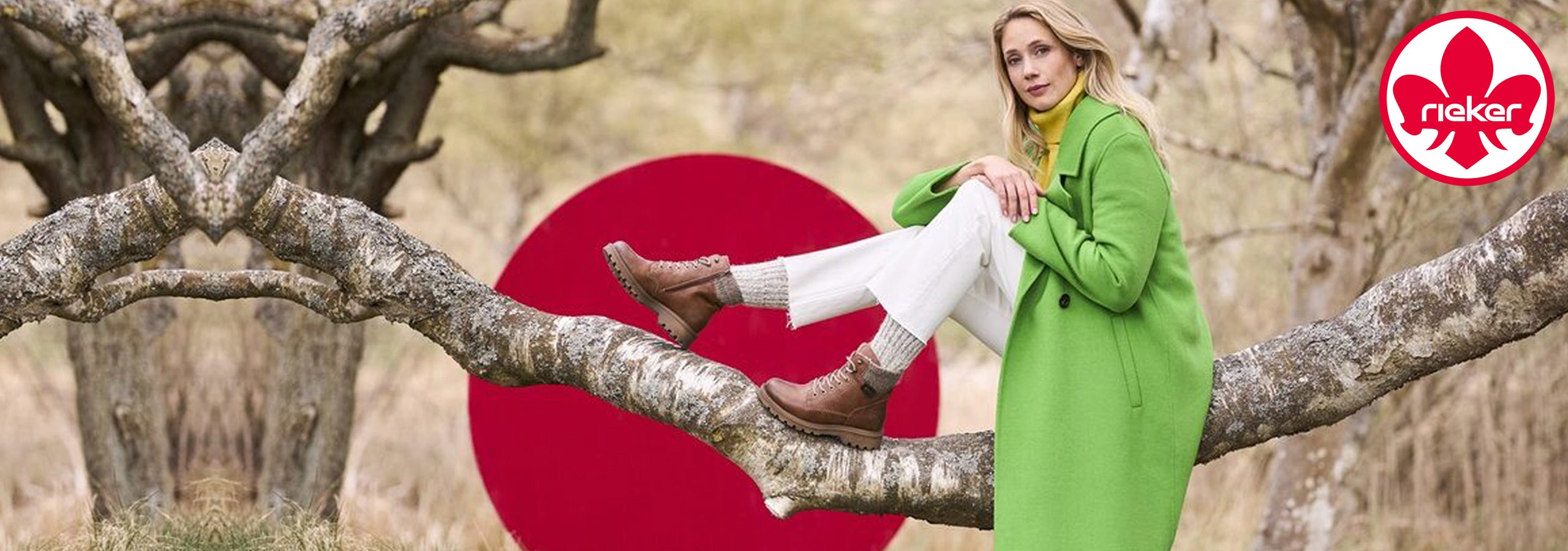 Woman in a green coat sitting on a tree branch with a red circle and brand logo in the background